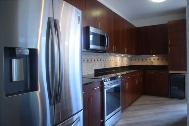 a kitchen with stainless steel appliances granite countertop a refrigerator stove and sink