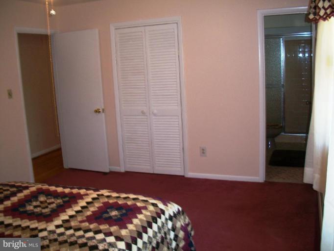 14608 Sturtevant Road Silver Spring, MD 20905 - Photo 15 of 27 a bedroom with a bed and a mirror