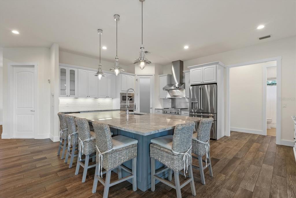 6816 Hawkins Road Sarasota, FL 34241 - Photo 11 of 60 a kitchen with stainless steel appliances a dining table chairs and wooden floor
