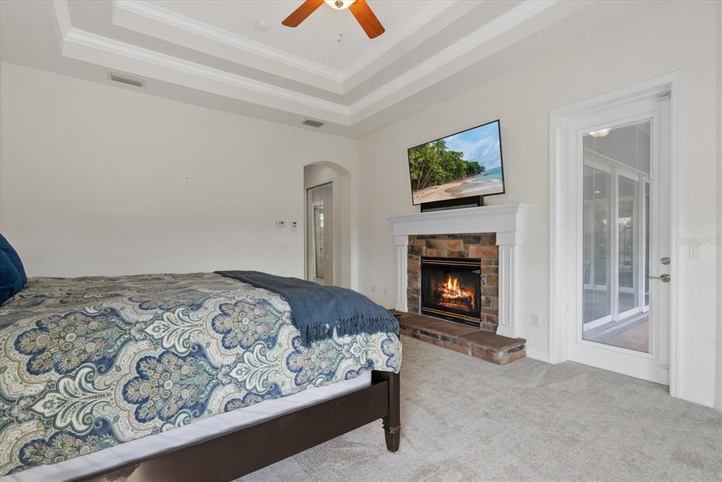 6816 Hawkins Road Sarasota, FL 34241 - Photo 17 of 60 a bedroom with a bed and a fireplace