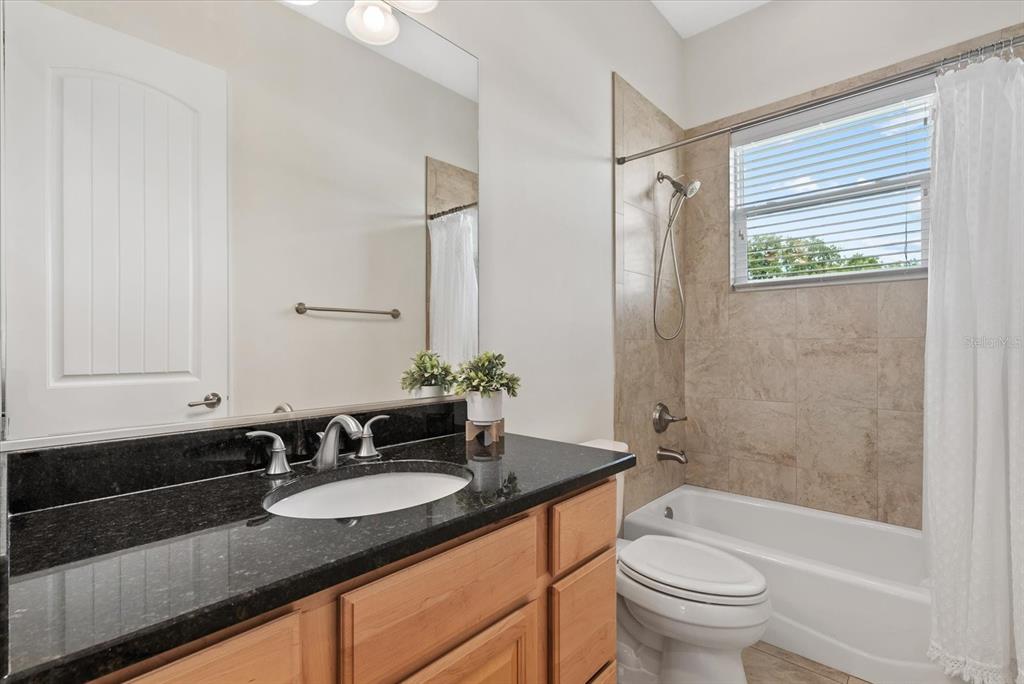 6816 Hawkins Road Sarasota, FL 34241 - Photo 24 of 60 a bathroom with a granite countertop sink toilet and shower