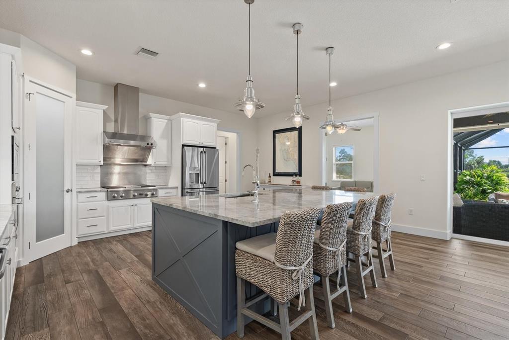 6816 Hawkins Road Sarasota, FL 34241 - Photo 10 of 60 a kitchen with stainless steel appliances a dining table chairs stove refrigerator and cabinets
