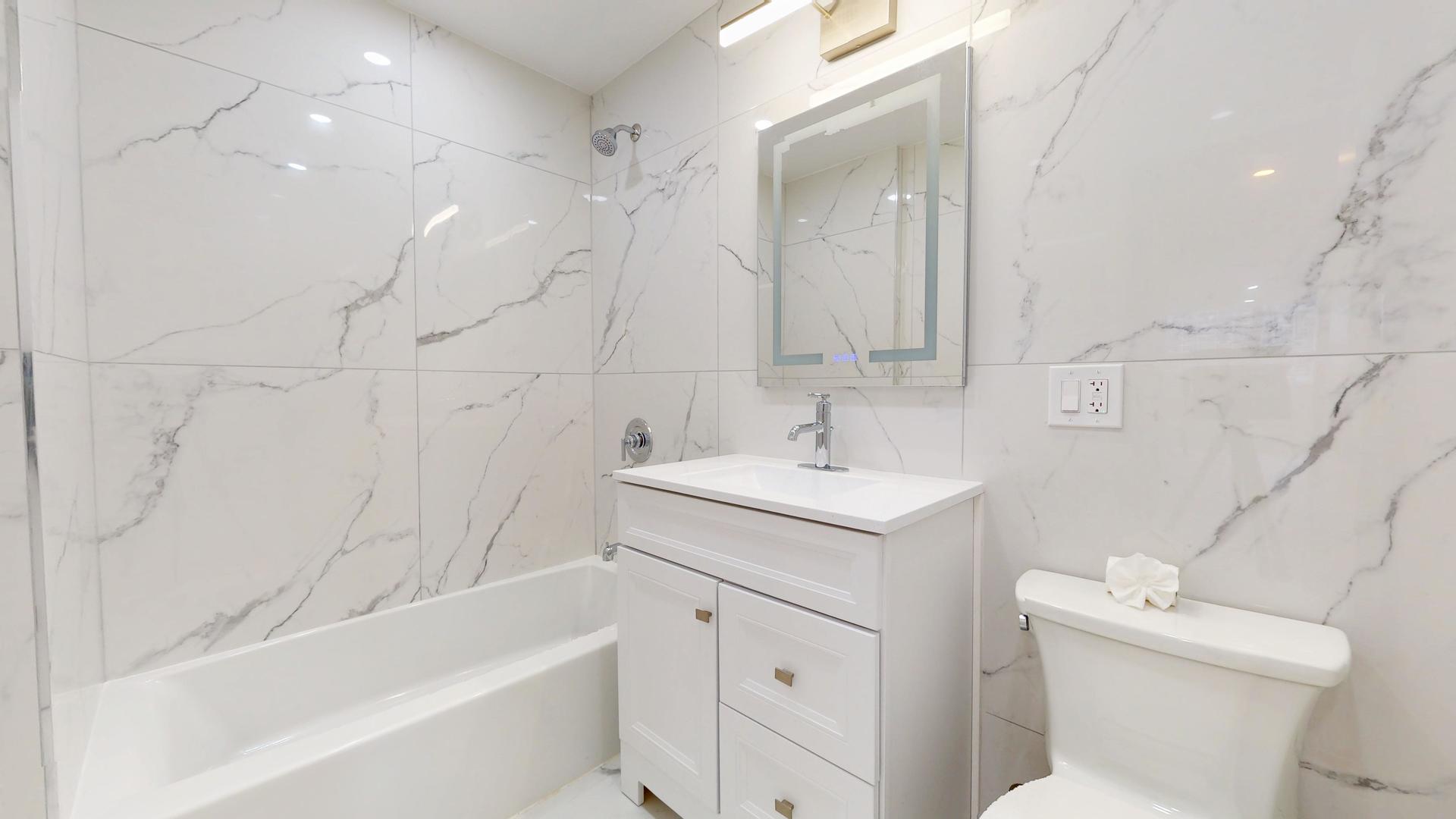 6301 North Sheridan Road, Unit 17G Chicago, IL 60660 - Photo 12 of 14 a bathroom with a sink toilet vanity and bathtub