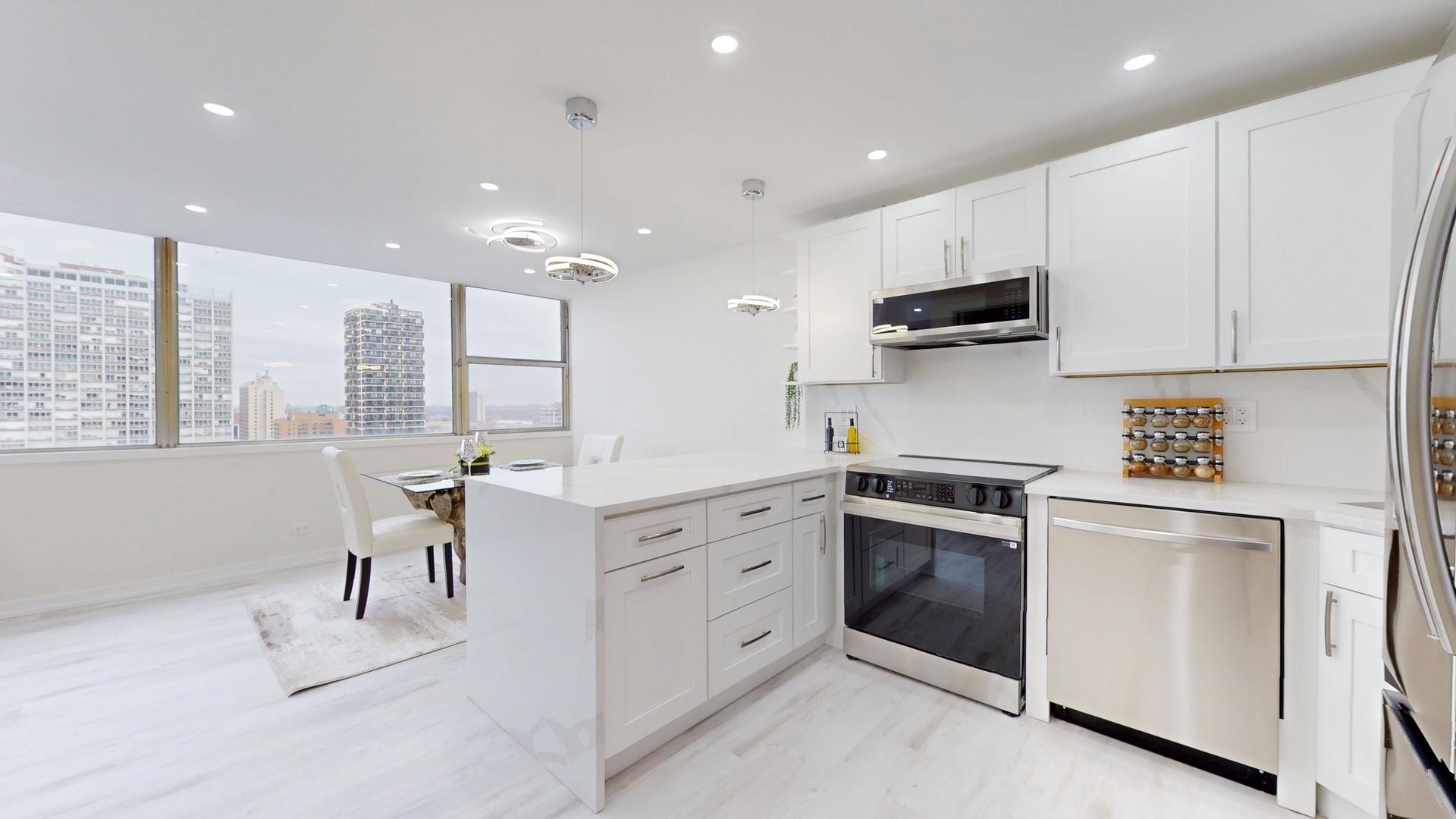 6301 North Sheridan Road, Unit 17G Chicago, IL 60660 - Photo 8 of 14 a kitchen with white cabinets and stainless steel appliances