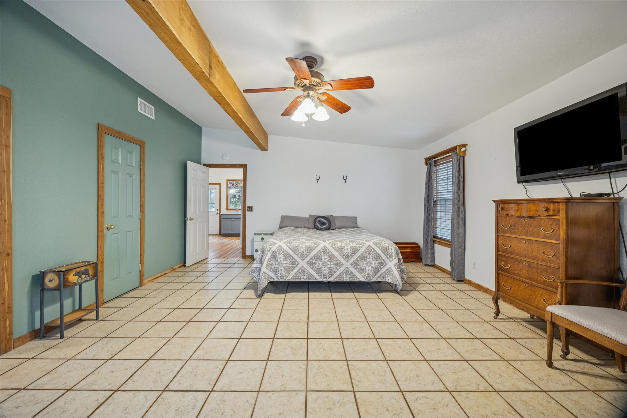 3502 1869th Ranch Liberty Hill, TX 78642 - Photo 13 of 20 Bedroom with beamed ceiling, light tile patterned floors, and ceiling fan