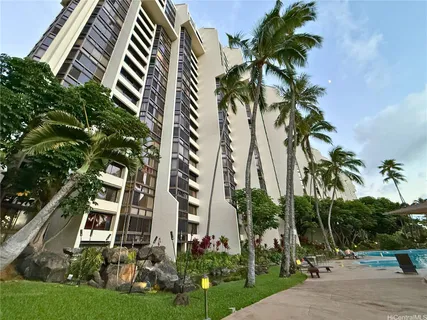 a front view of multi story residential apartment building with yard and entryway