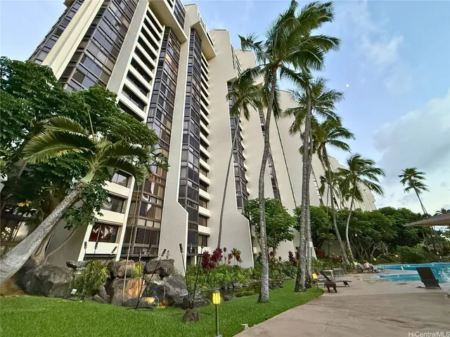 a front view of multi story residential apartment building with yard and entryway