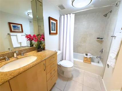 a bathroom with a granite countertop sink mirror vanity and toilet