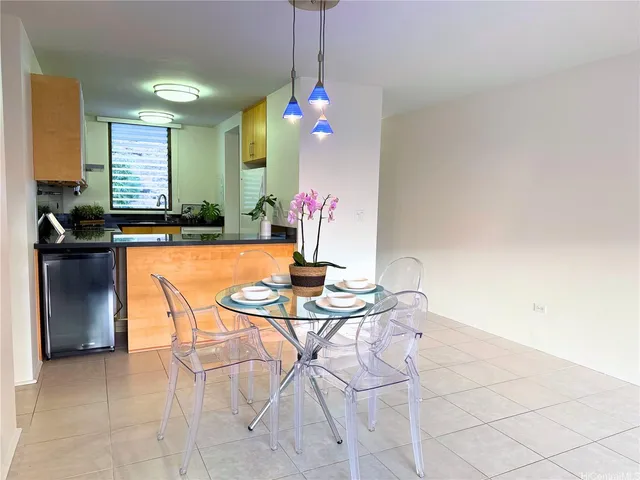 a dining room with chandelier and wooden floor
