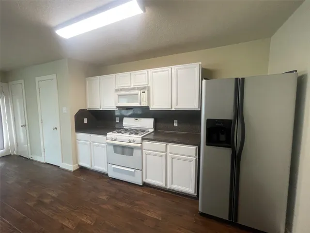 a kitchen with stainless steel appliances a refrigerator sink and microwave
