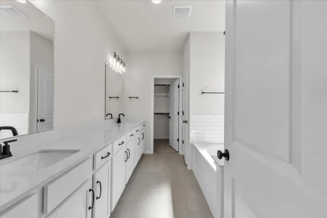 a spacious bathroom with double vanity and mirrors