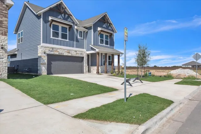 a front view of a house with a garden and yard