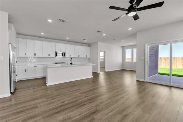 a view of kitchen with cabinets microwave and stove