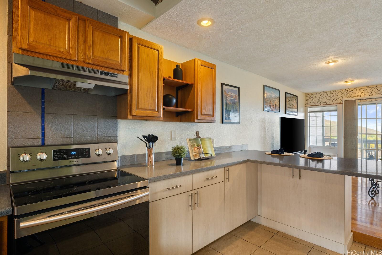 92-905 Hame Place, Unit 19203 Kapolei, HI 96707 - Photo 6 of 23 a kitchen with stainless steel appliances a stove sink and cabinets