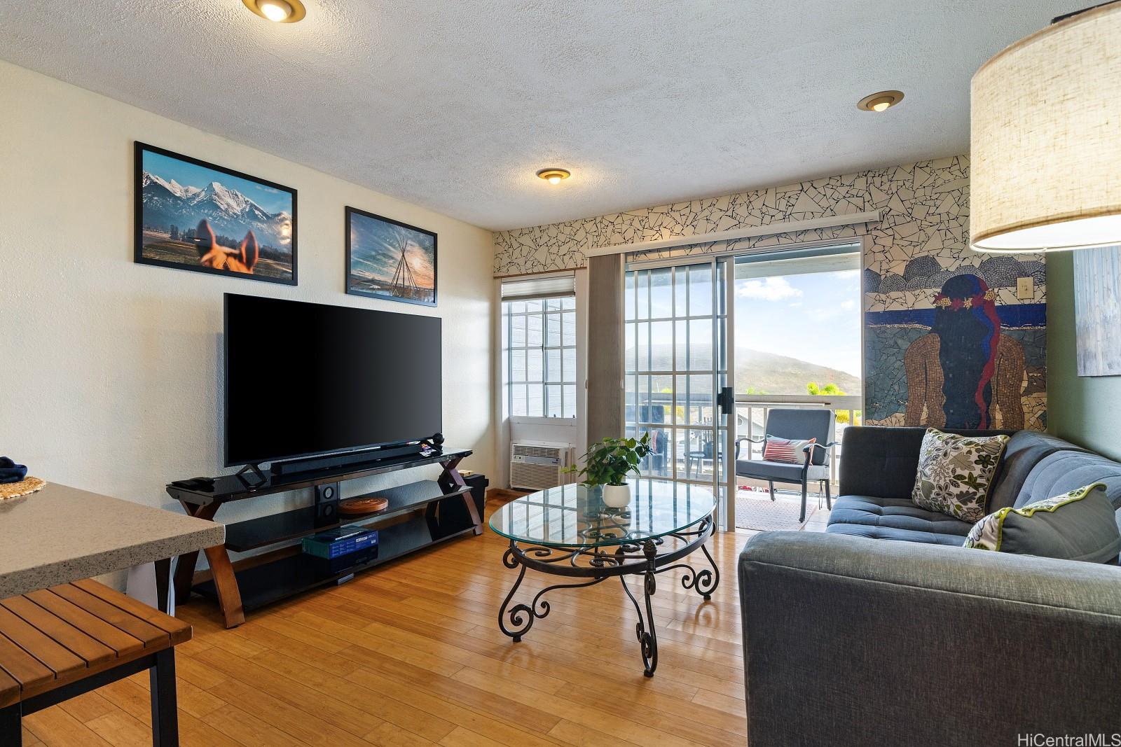 92-905 Hame Place, Unit 19203 Kapolei, HI 96707 - Photo 7 of 23 a living room with furniture and a flat screen tv