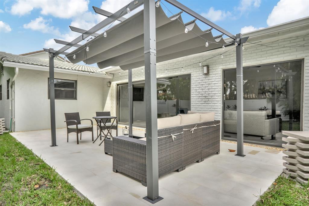1035 Northwest 5th Avenue Boca Raton, FL 33432 - Photo 44 of 50 a view of a patio with dining table and chairs
