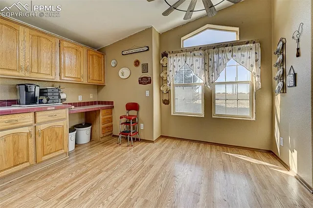 a view of a kitchen with fridge and wooden floors