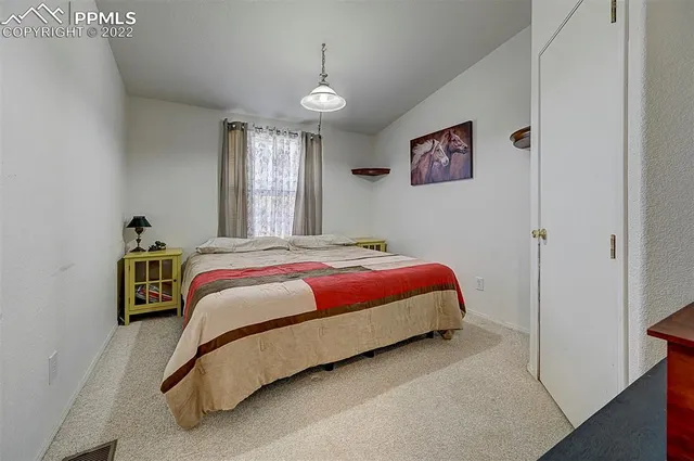 a spacious bedroom with a bed and a window