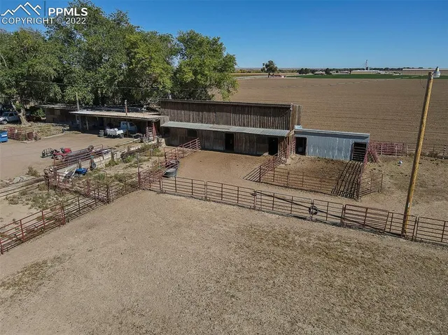 a view of house with ocean view and trees in the background