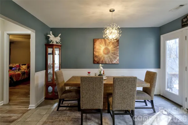 a view of a dining room with furniture and chandelier