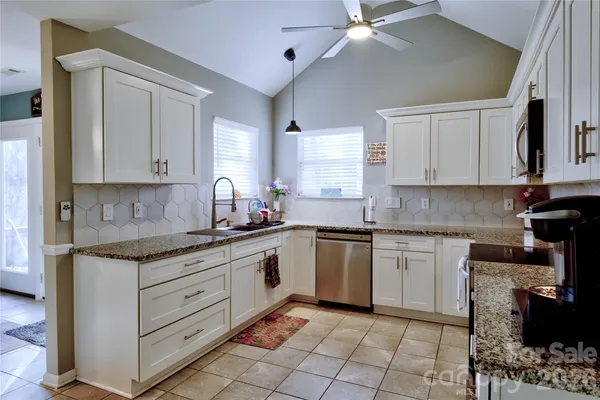 a kitchen with stainless steel appliances granite countertop a sink and a stove
