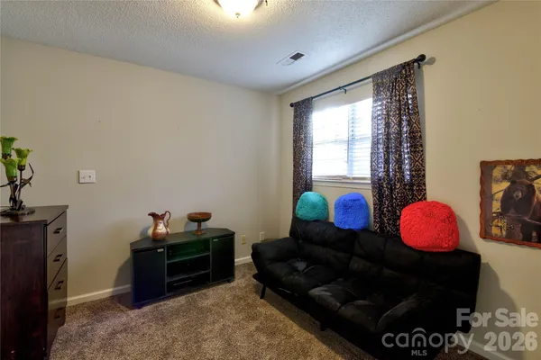 a living room with furniture a flat screen tv and a window