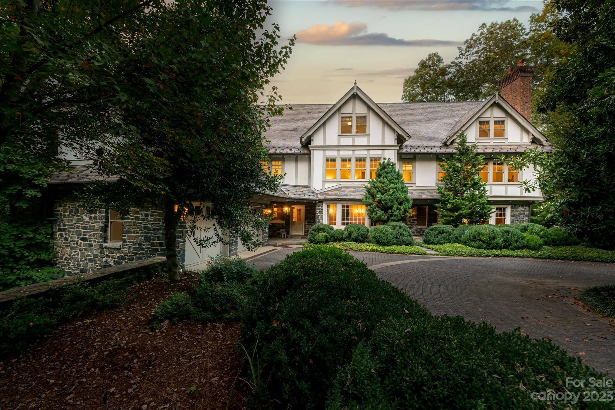 a front view of a house with a yard and green space