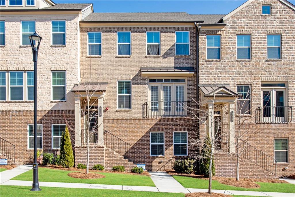 108 Grand Approach Drive Woodstock, GA 30188 - Photo 1 of 1 a front view of a residential apartment building with a yard