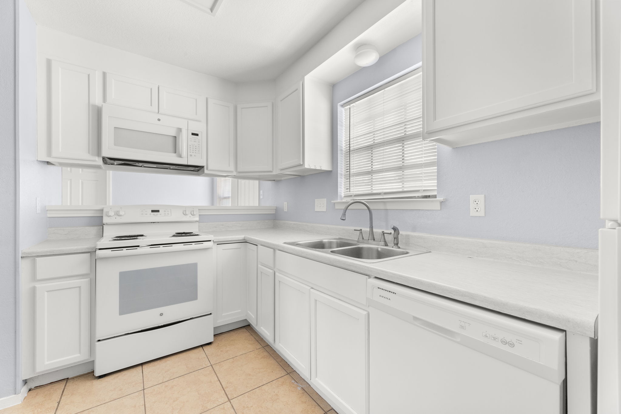 3802 Foust Trail, Unit A Georgetown, TX 78628 - Photo 12 of 34 A well-equipped kitchen features white cabinetry and appliances with ample counter space.