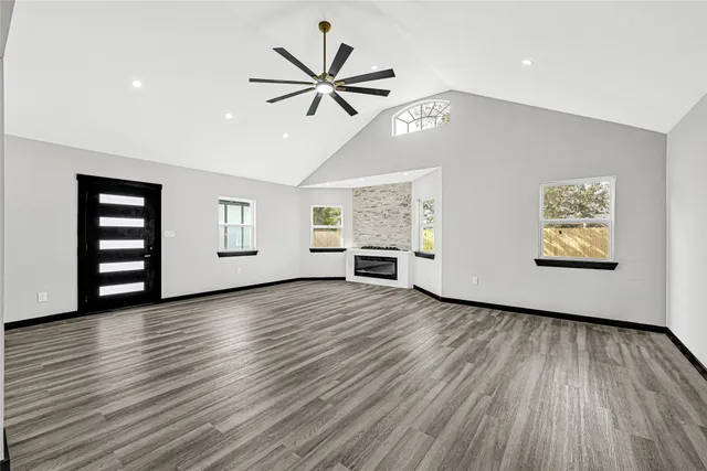 a view of a room with wooden floor and a ceiling fan