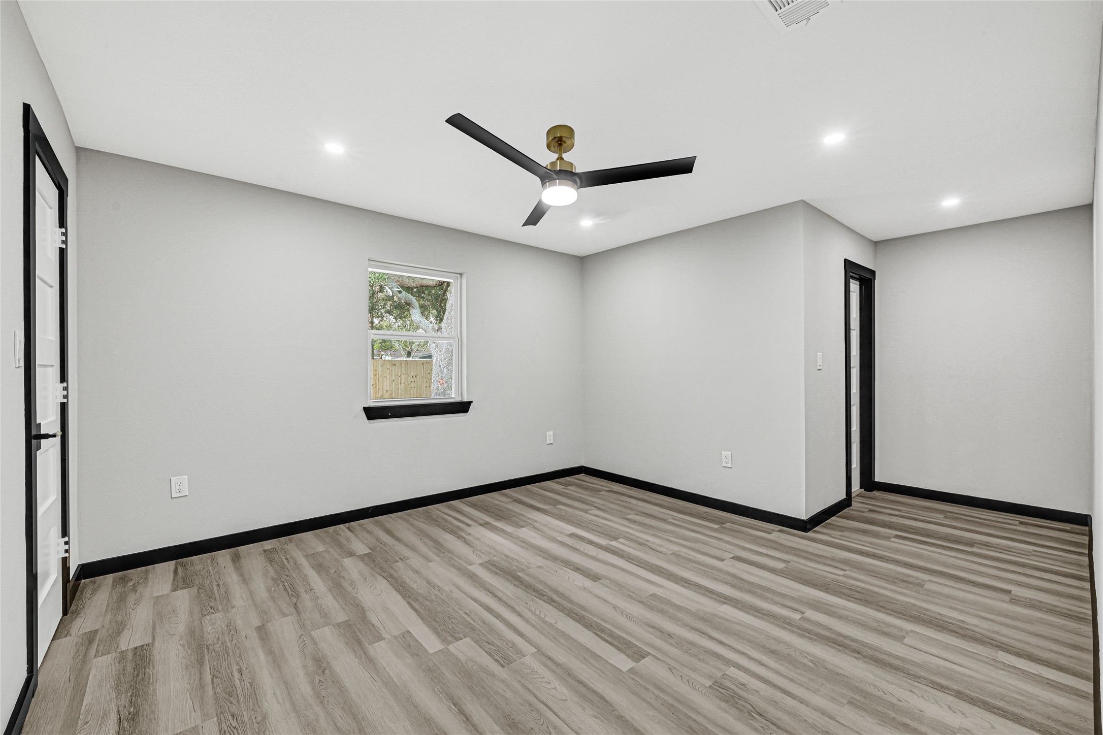 16240 2nd Street Rosharon, TX 77583 - Photo 18 of 26 a view of an empty room with wooden floor and a ceiling fan