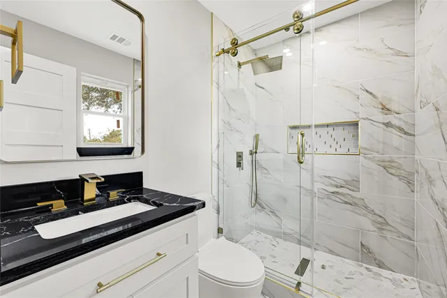 a bathroom with a toilet sink and mirror