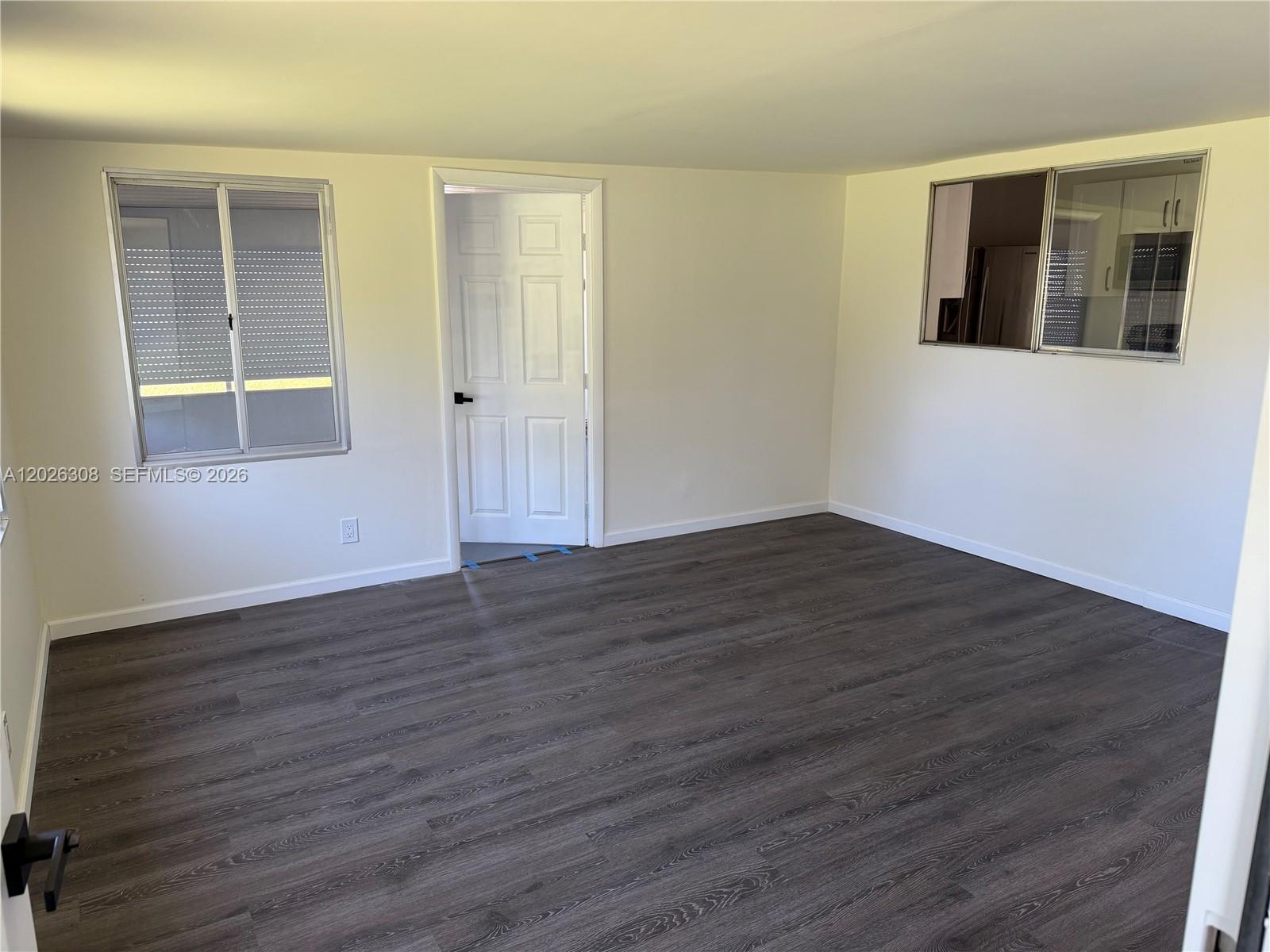 653 Atlas Avenue Northeast Palm Bay, FL 32905 - Photo 15 of 22 a view of an empty room with wooden floor and windows