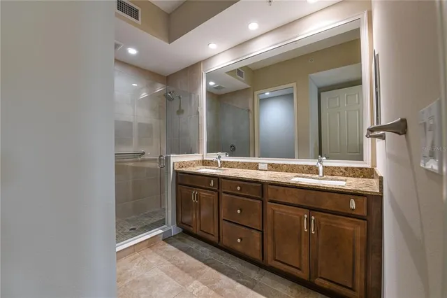 a bathroom with a granite countertop sink a toilet and shower