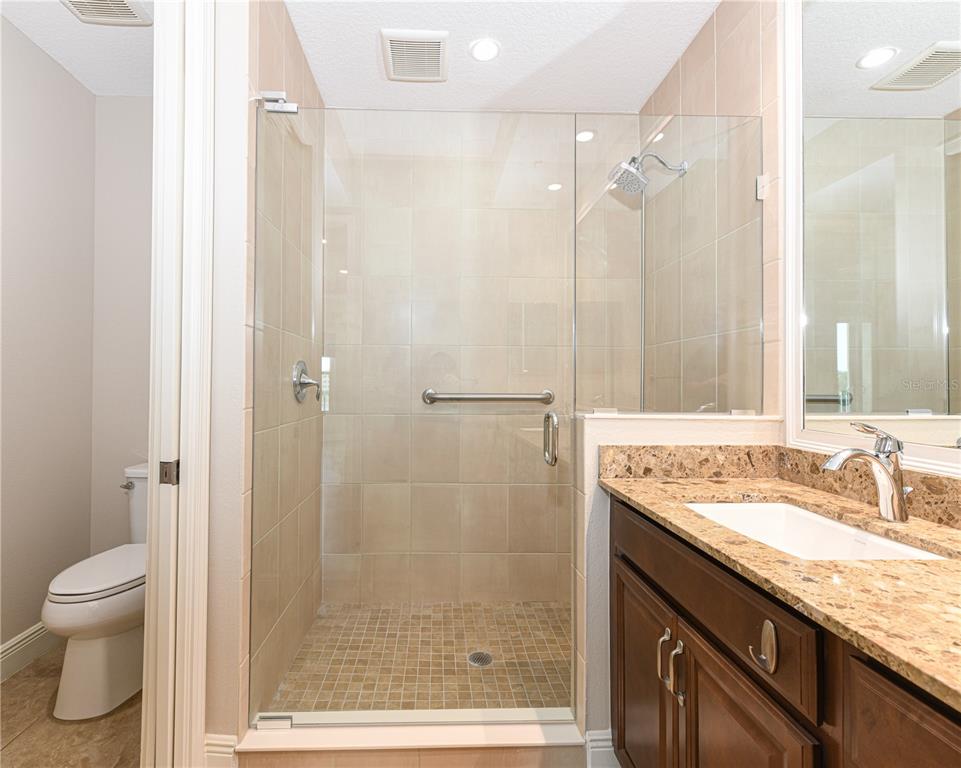 10520 Boardwalk Loop, Unit 202 Bradenton, FL 34202 - Photo 13 of 23 a bathroom with a granite countertop sink a toilet and shower