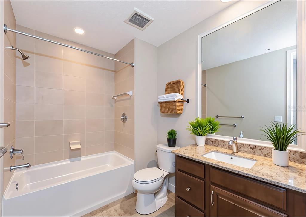10520 Boardwalk Loop, Unit 202 Bradenton, FL 34202 - Photo 15 of 23 a bathroom with a granite countertop sink toilet a large mirror a shower and a bathtub