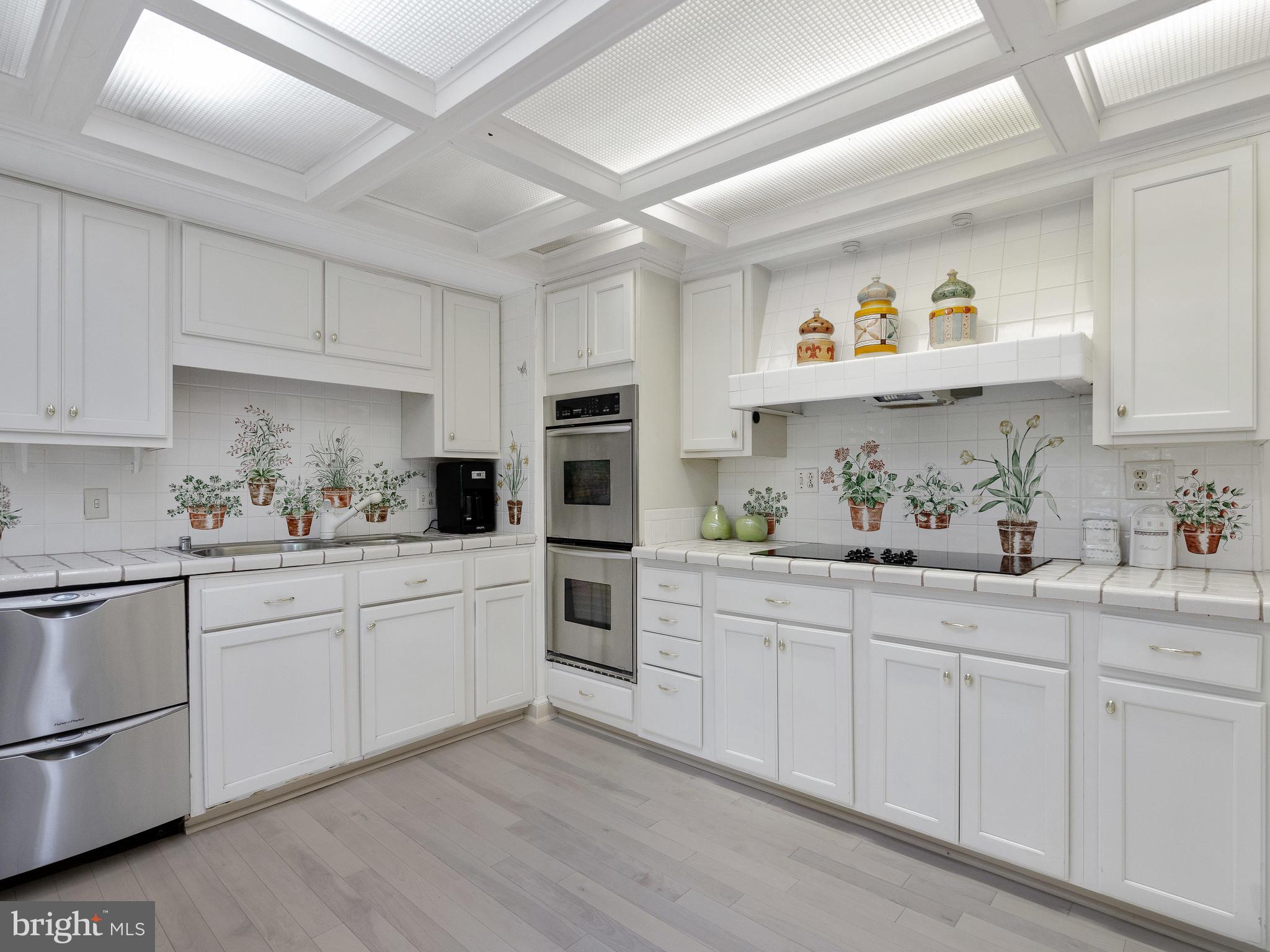 10420 Glen Road Potomac, MD 20854 - Photo 28 of 54 a kitchen with kitchen island white cabinets and white appliances