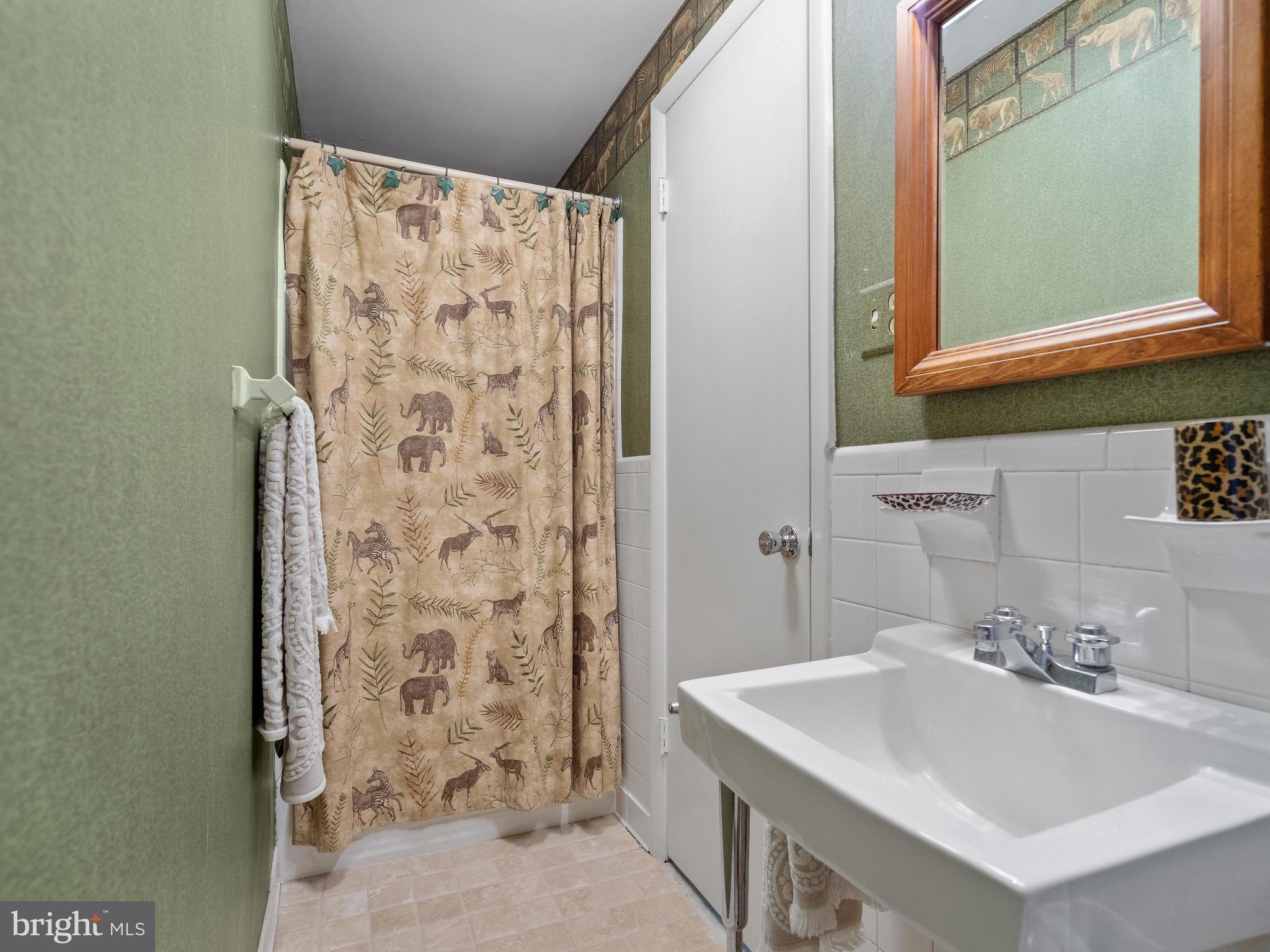 10420 Glen Road Potomac, MD 20854 - Photo 37 of 54 a bathroom with a sink a mirror and a shower