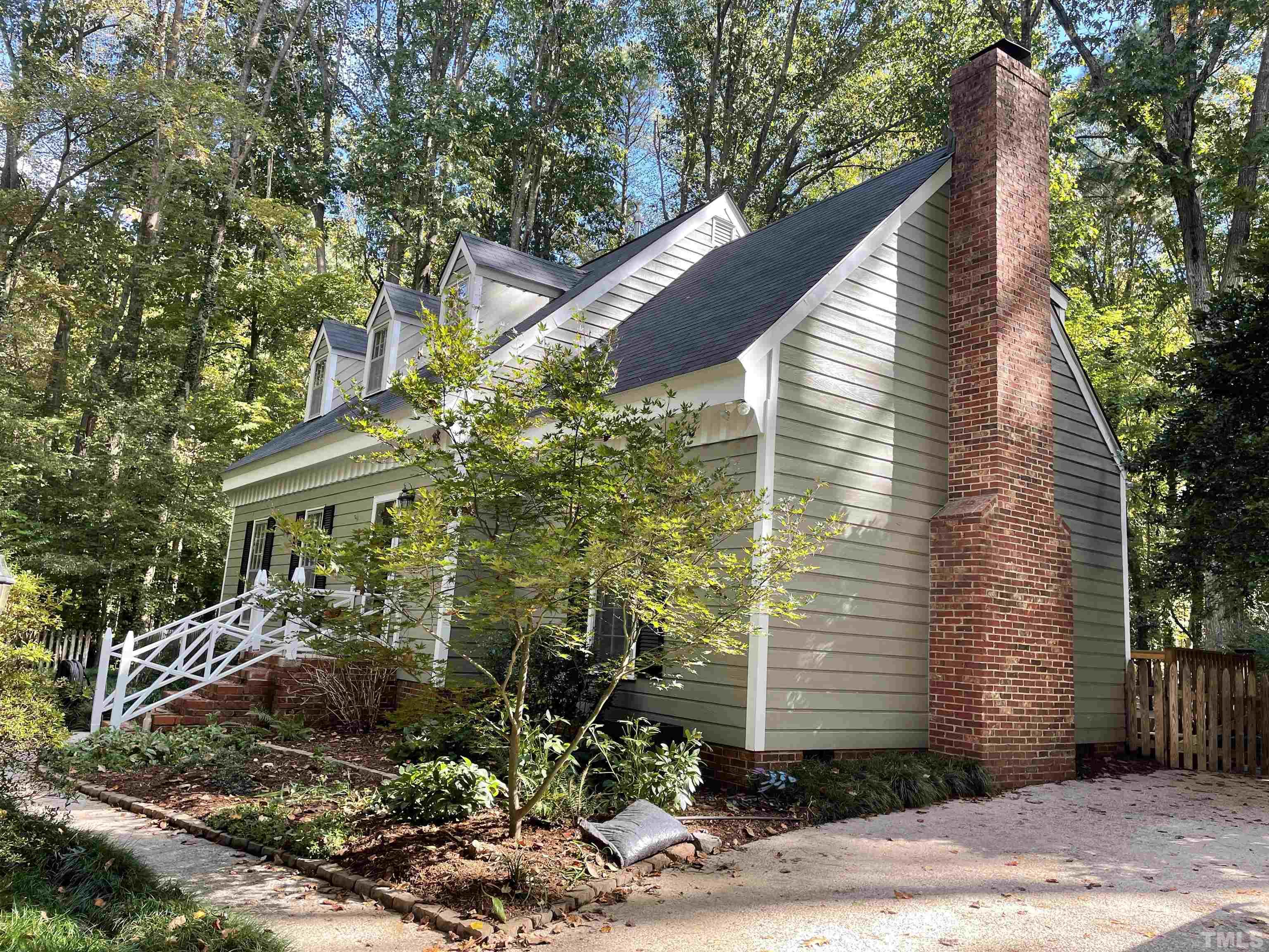 9616 Rock Creek Road Raleigh, NC 27613 - Photo 2 of 28 a view of house with outdoor seating and covered with trees