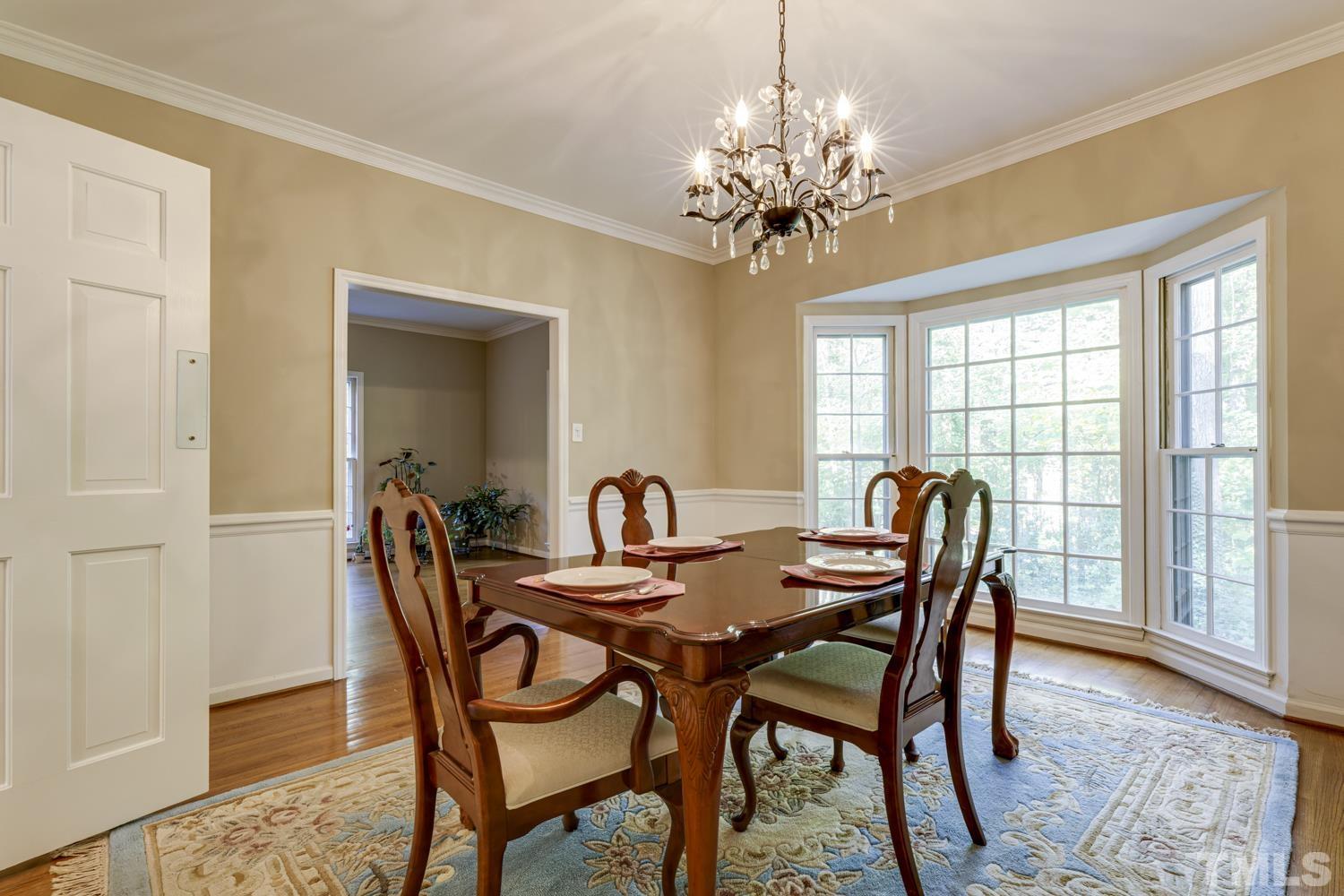 9616 Rock Creek Road Raleigh, NC 27613 - Photo 11 of 28 a view of a dining room with furniture a chandelier and wooden floor
