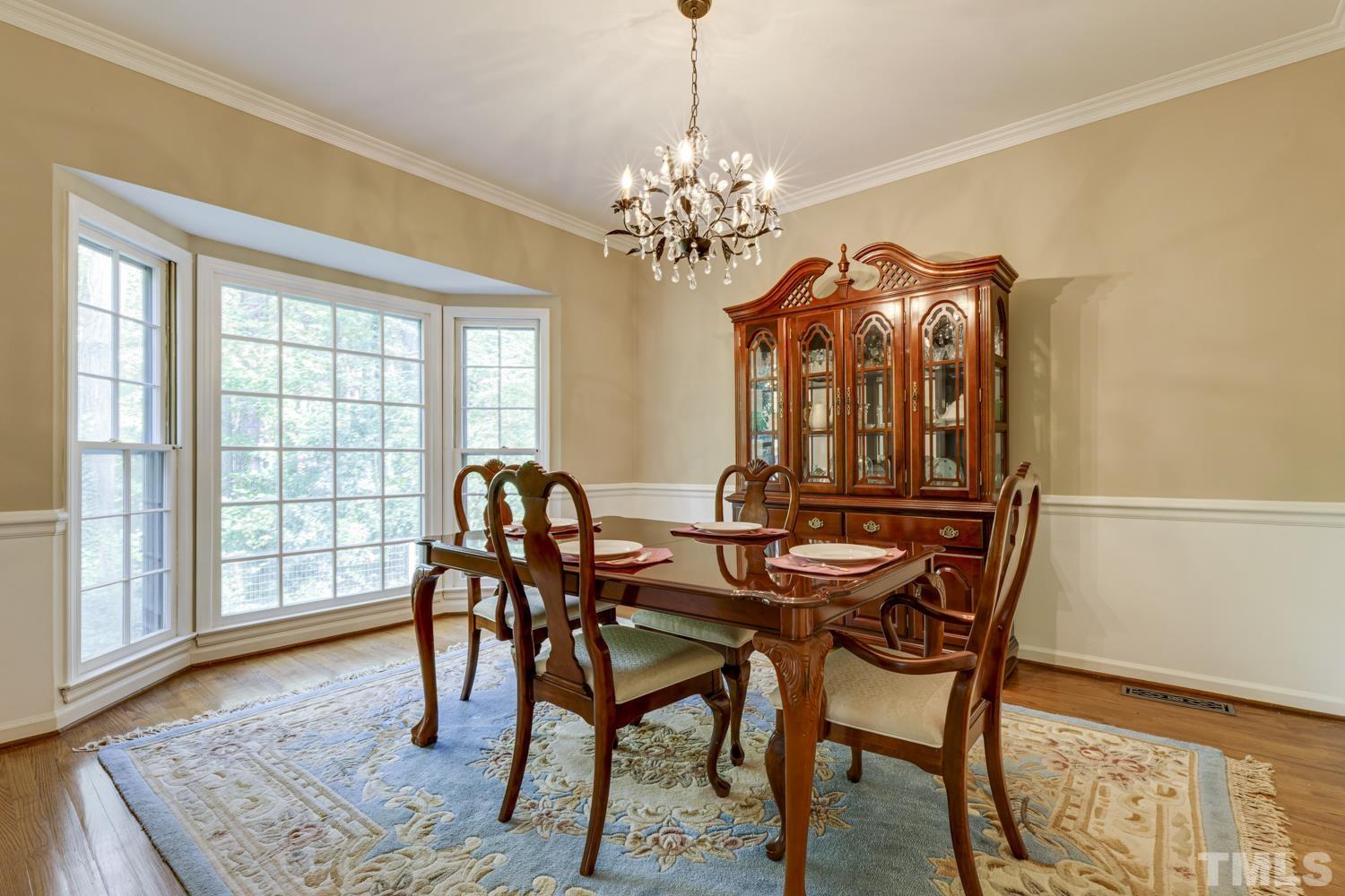 9616 Rock Creek Road Raleigh, NC 27613 - Photo 12 of 28 a view of a dining room with furniture wooden floor and chandelier