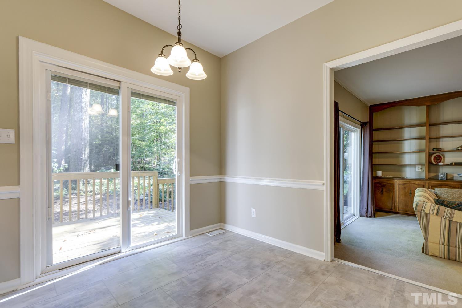 9616 Rock Creek Road Raleigh, NC 27613 - Photo 14 of 28 a view of an empty room with a fireplace and a window