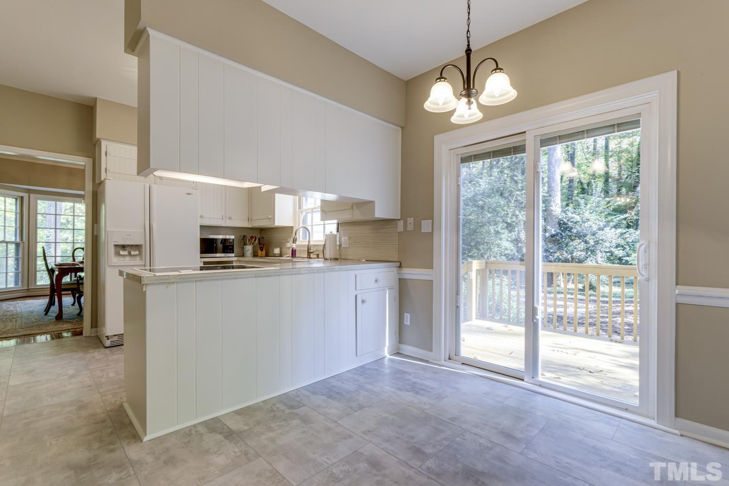 9616 Rock Creek Road Raleigh, NC 27613 - Photo 15 of 28 a kitchen with white cabinets and white appliances