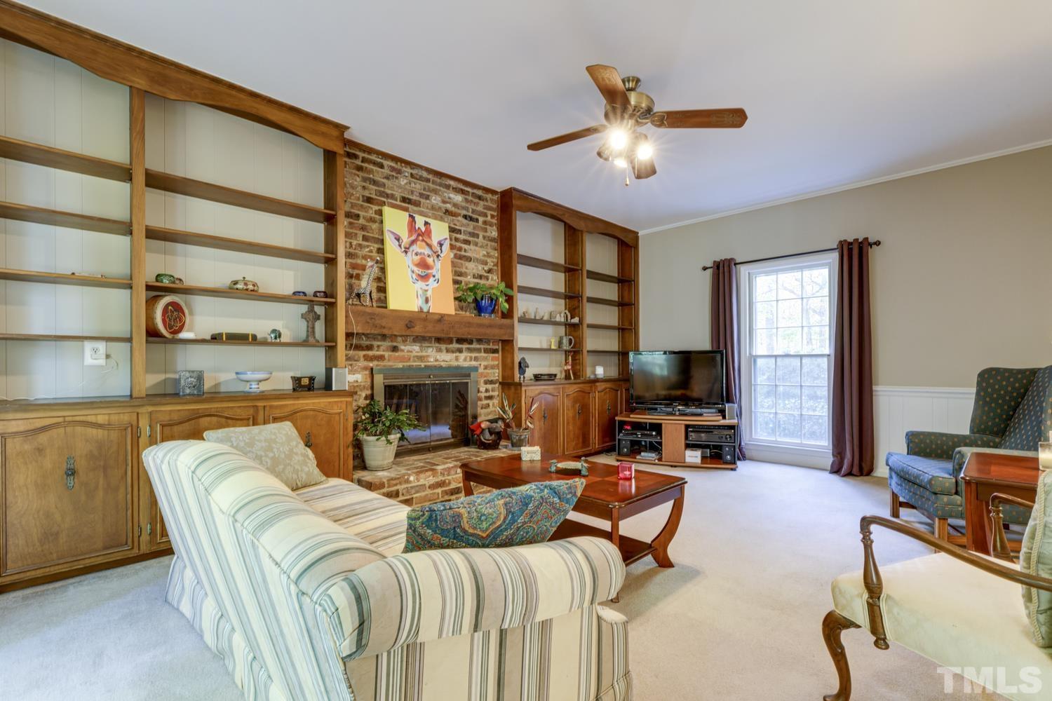 9616 Rock Creek Road Raleigh, NC 27613 - Photo 16 of 28 a living room with furniture a fireplace and a large window