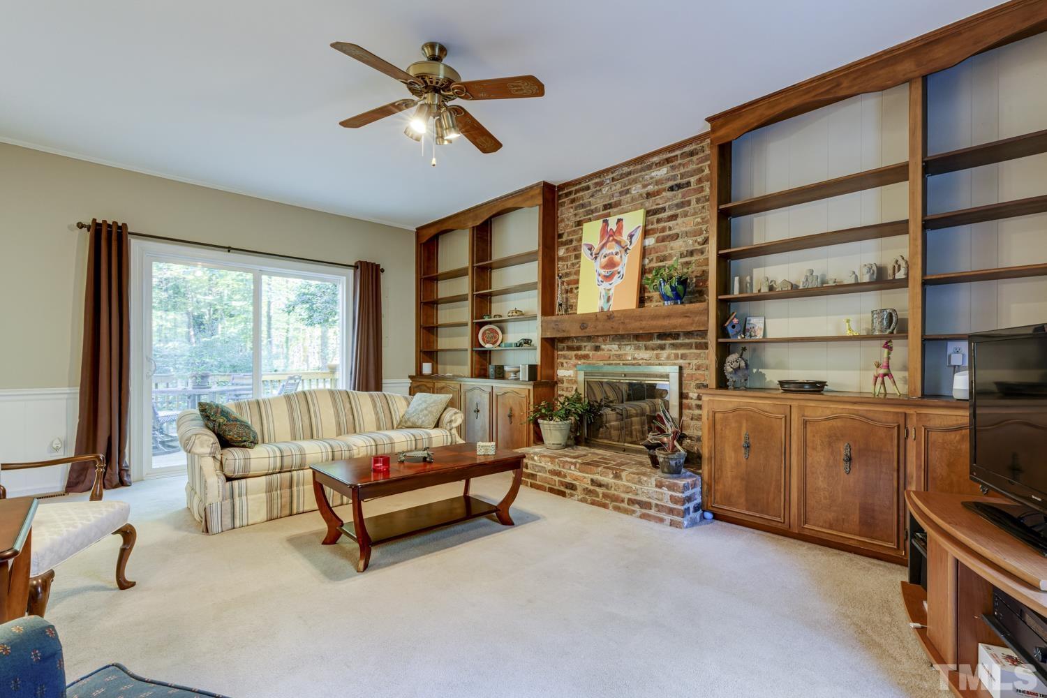 9616 Rock Creek Road Raleigh, NC 27613 - Photo 18 of 28 a living room with furniture a fireplace and a flat screen tv