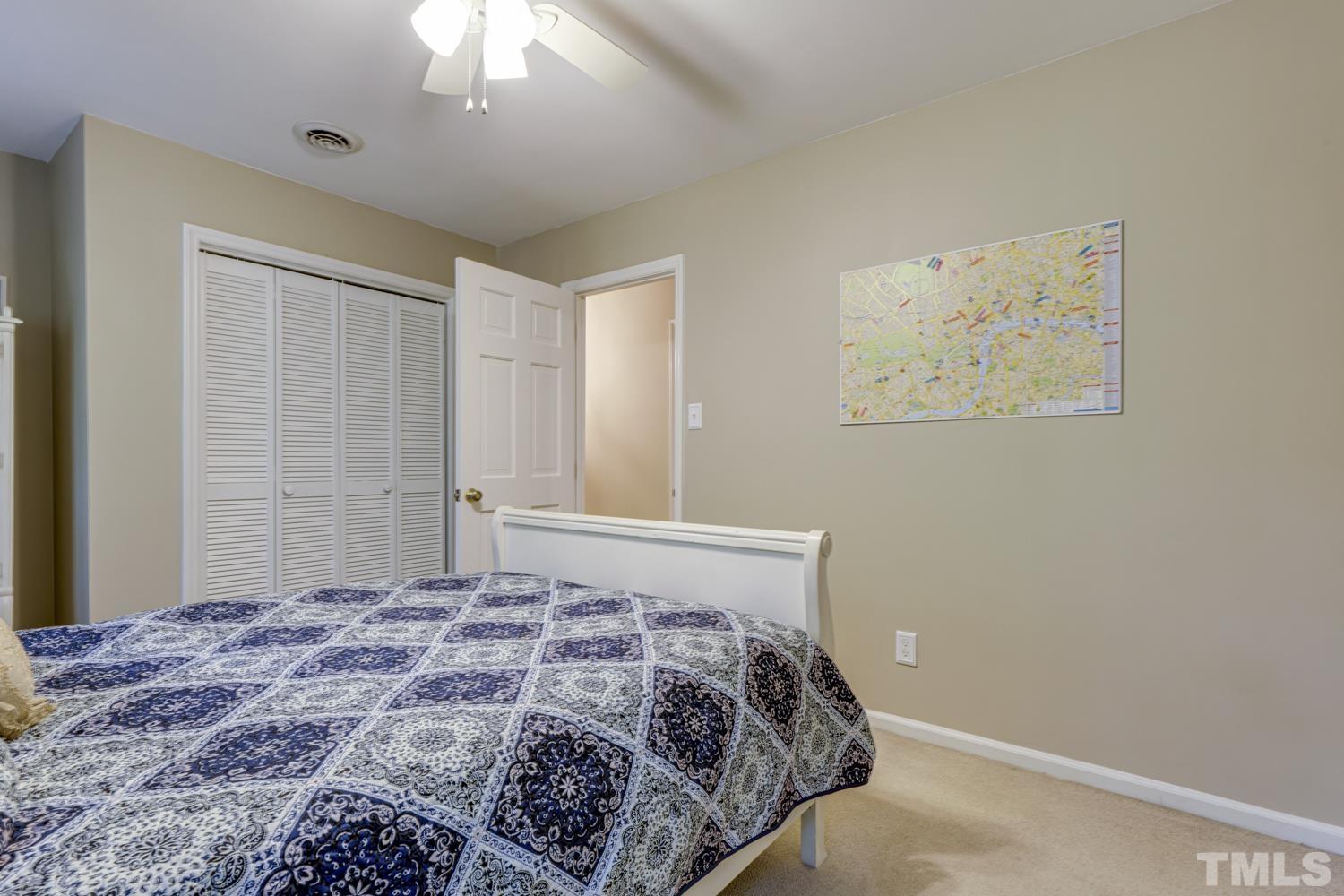 9616 Rock Creek Road Raleigh, NC 27613 - Photo 23 of 28 a bedroom with a bed and a chandelier