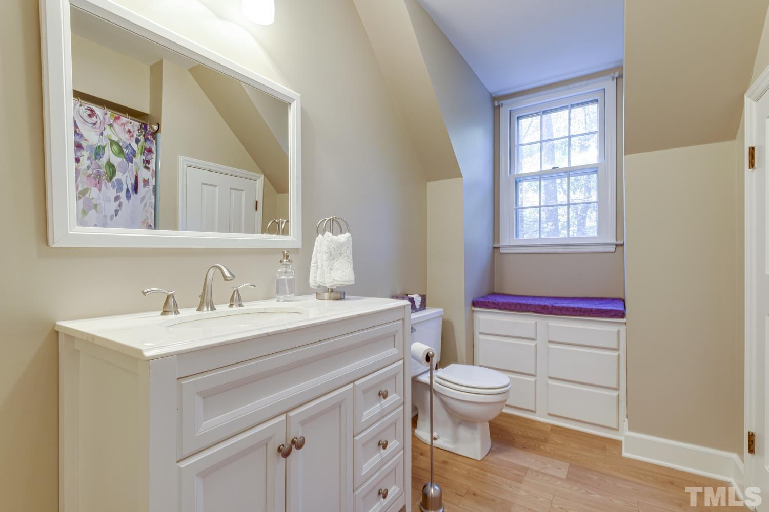 9616 Rock Creek Road Raleigh, NC 27613 - Photo 24 of 28 a bathroom with a sink a toilet and a window