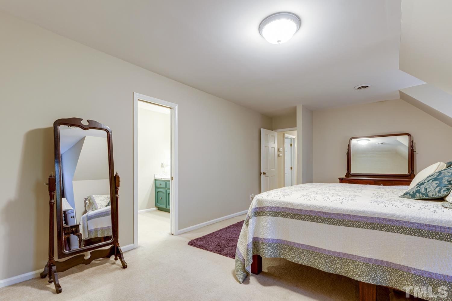9616 Rock Creek Road Raleigh, NC 27613 - Photo 26 of 28 a bedroom with a bed and a mirror