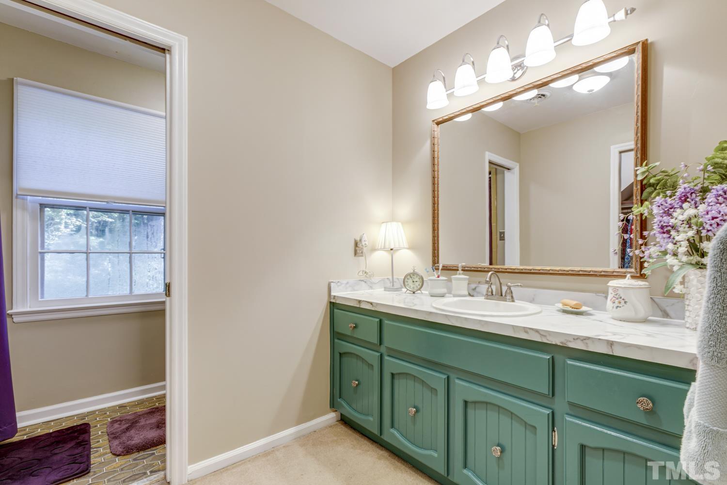 9616 Rock Creek Road Raleigh, NC 27613 - Photo 27 of 28 a bathroom with a double vanity sink mirror and next to a window