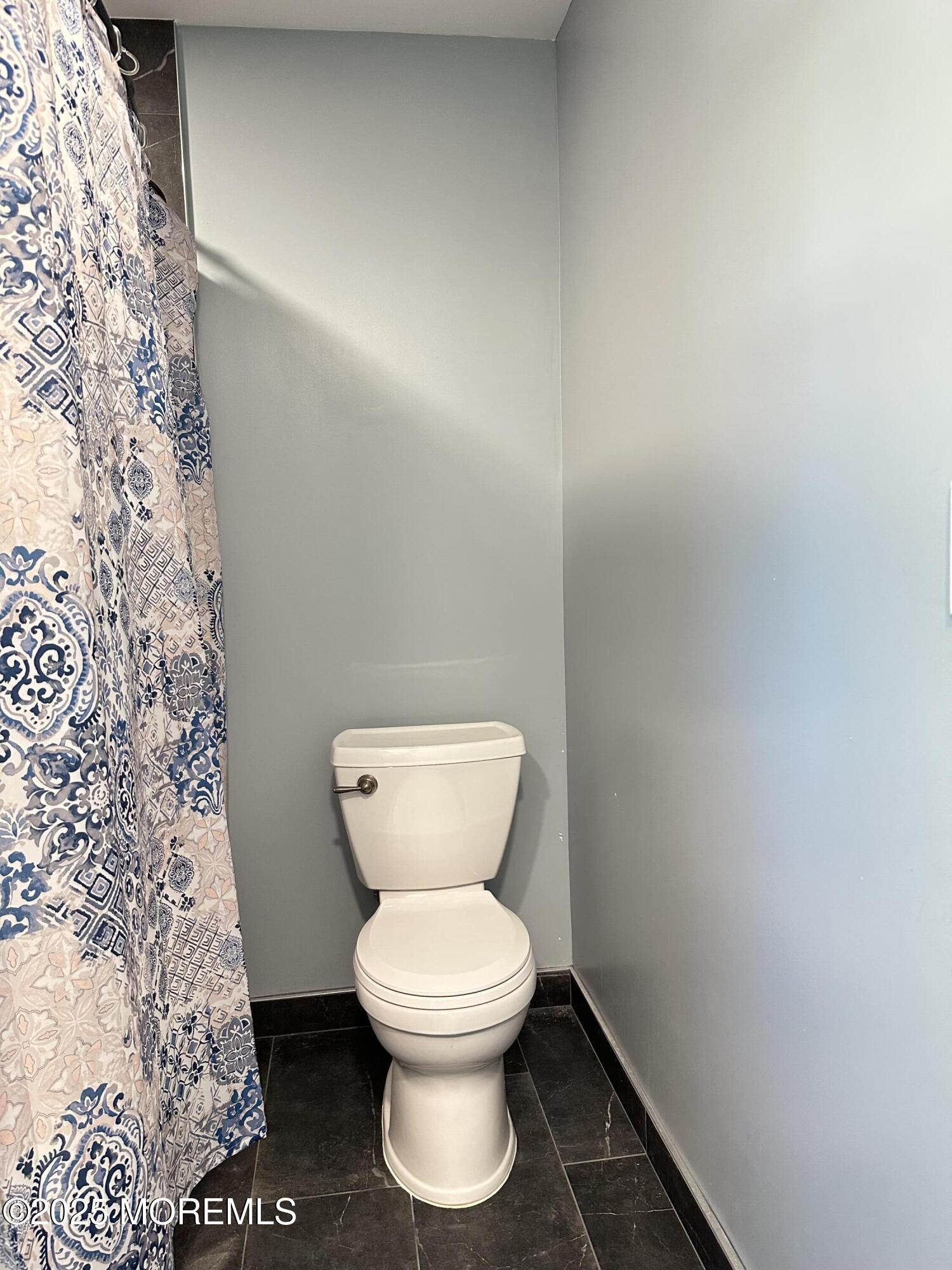 45 Springhill Drive Howell, NJ 07731 - Photo 18 of 22 a white toilet sitting next to a shower curtain